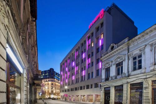 a building with purple lights on the side of it at Moxy Bucharest Old Town in Bucharest