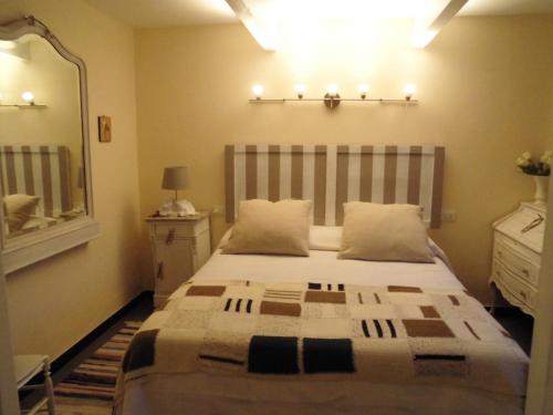 1 dormitorio con 1 cama grande y espejo en Il Portico Suite de Charme en Vescina