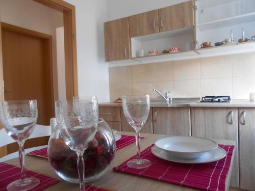 a table with three wine glasses and a plate on it at Apartment Luna 4 person in Bribir