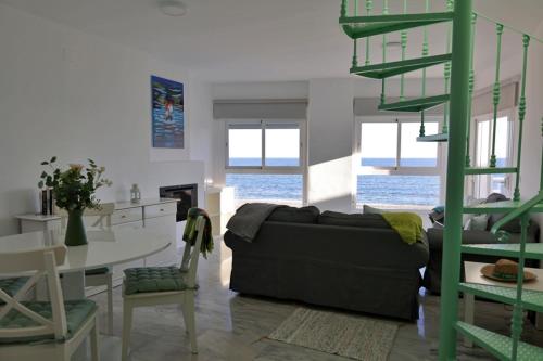 uma sala de estar com um sofá e uma mesa em Sea front Apartment in La Cala de Mijas em La Cala de Mijas