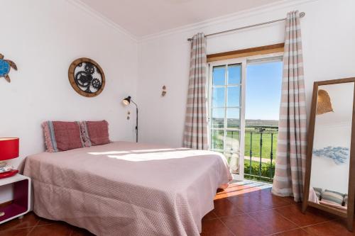 a bedroom with a bed and a large window at Beach Front View Armacao de Pera Flat in Armação de Pêra