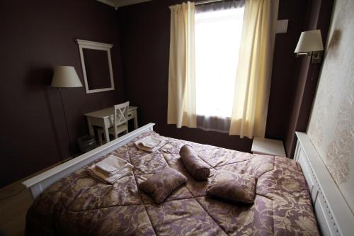 a bedroom with a bed with pillows and a window at Veski Külalistemaja in Kantküla