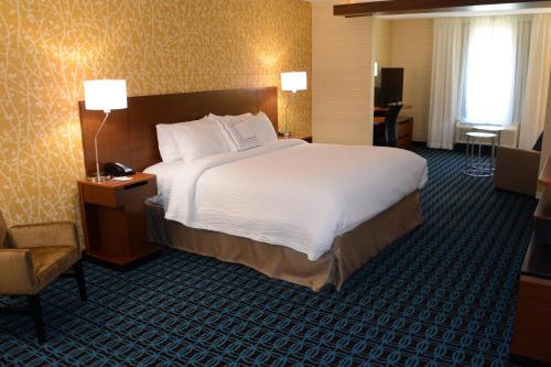 サマセットにあるFairfield Inn & Suites By Marriott Somersetの大きなベッドと椅子が備わるホテルルームです。