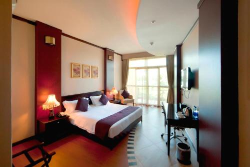 a hotel room with a bed and a window at Protea Hotel by Marriott Entebbe in Entebbe