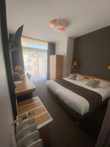 a bedroom with a bed and a desk and a staircase at Hotel Des Lices in Rennes