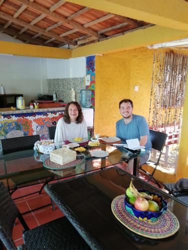 a man and a woman sitting at a table with food at Villa Margarita in Puerto Colombia