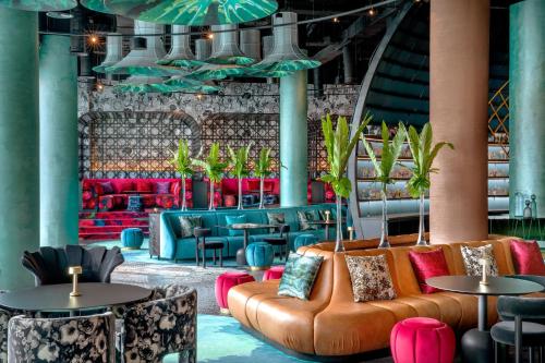 a lobby with a couch and tables and chairs at W Abu Dhabi - Yas Island in Abu Dhabi