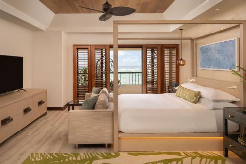 ein Schlafzimmer mit einem großen Bett und einem TV in der Unterkunft Sheraton Kauai Coconut Beach Resort in Kapaa
