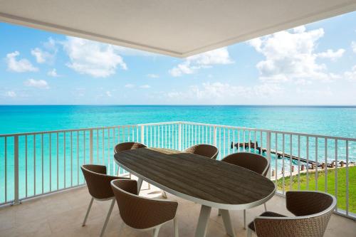 a table and chairs on a balcony with the ocean at The St. Regis Bermuda Resort in Saint George