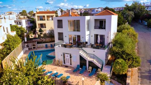 widok z powietrza na biały dom z basenem w obiekcie Wonderful Villa in Chania with Private Pool, Panoramic Sea Views & Spacious Interiors w mieście Agios Onoufrios