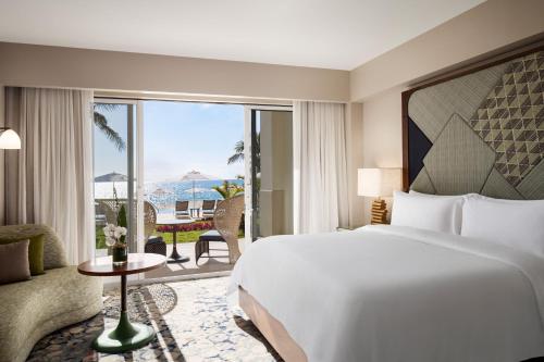 The St. Regis Bermuda Resort في Saint George: غرفة نوم مع سرير وإطلالة على المحيط