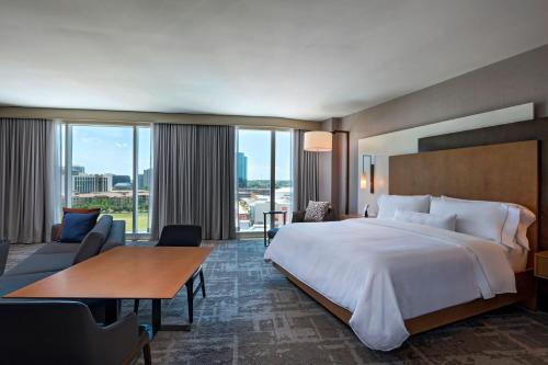a hotel room with a large bed and a large window at The Westin Irving Convention Center at Las Colinas in Irving