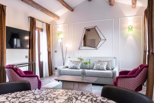 uma sala de estar com um sofá e cadeiras em Be Mate Ponte di Rialto em Veneza