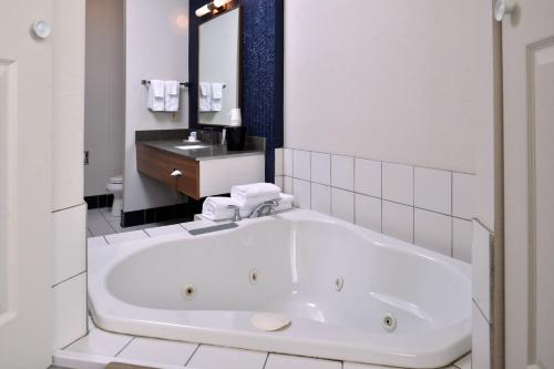 a white bathroom with a tub and a sink at Fairfield Inn and Suites Beloit in Beloit