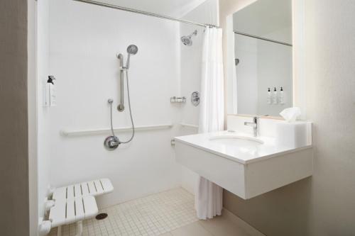 a white bathroom with a sink and a shower at SpringHill Suites Boulder Longmont in Longmont