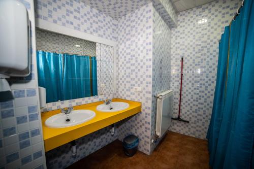 Baño con 2 lavabos y espejo en Albergue de Cuéllar, en Cuéllar
