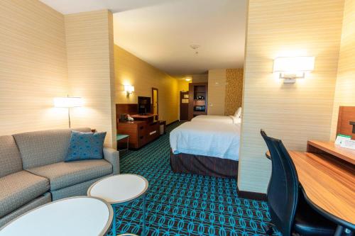 a hotel room with a bed and a couch at Fairfield Inn & Suites by Marriott Atlanta Woodstock in Woodstock