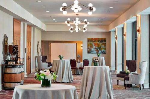 a meeting room with two tables and chairs and a chandelier at Napa Valley Marriott Hotel & Spa in Napa