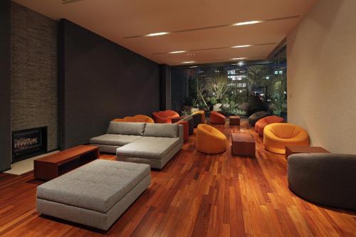 sala de estar con sofás, sillas y chimenea en Cocochee Hotel Numazu, en Numazu