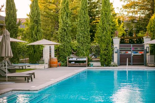 a swimming pool with a patio and umbrella and trees at Napa Valley Marriott Hotel & Spa in Napa