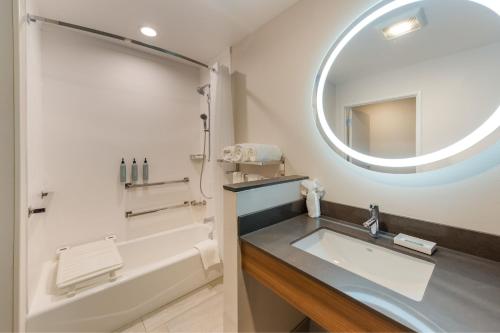 La salle de bains est pourvue d'une baignoire, d'un lavabo et d'un miroir. dans l'établissement Fairfield by Marriott Inn & Suites Columbus Canal Winchester, à Canal Winchester
