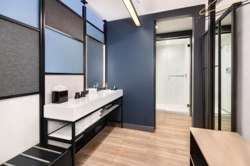 a bathroom with a sink and a mirror at Aloft Cincinnati West Chester in West Chester