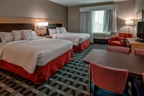 ホット・スプリングスにあるTownePlace Suites by Marriott Hot Springsのベッド2台とテーブルが備わるホテルルームです。