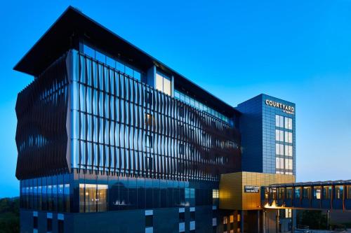 a large building with a lot of windows at Courtyard by Marriott Exeter Sandy Park in Exeter