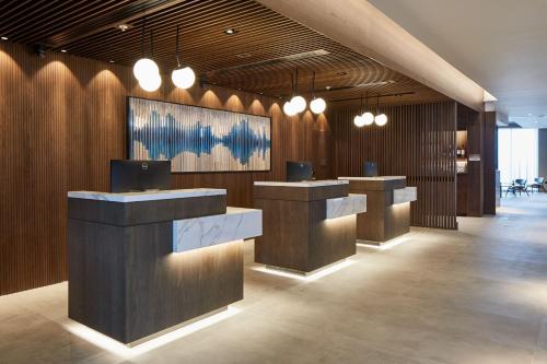 a lobby with a row of counters and lights at Courtyard by Marriott Exeter Sandy Park in Exeter