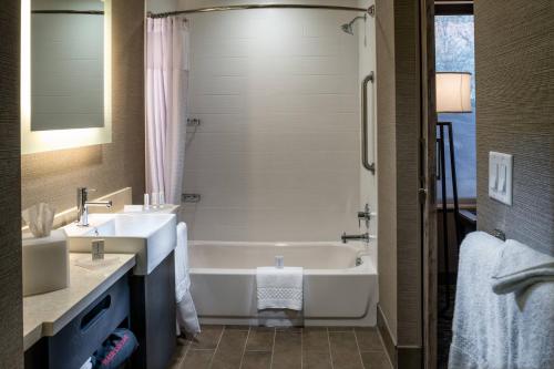 a bathroom with a white tub and a sink at SpringHill Suites by Marriott Springdale Zion National Park in Springdale