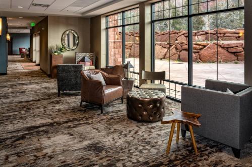 a lobby with chairs and tables and windows at SpringHill Suites by Marriott Springdale Zion National Park in Springdale