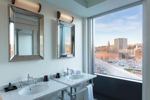 a bathroom with two sinks and a large window at Aloft Providence Downtown in Providence
