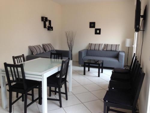 un salon avec une table, des chaises et un canapé dans l'établissement Villa jfm, à Saint-Aygulf