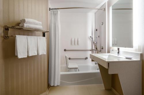 Baño blanco con bañera y lavamanos en SpringHill Suites by Marriott Colorado Springs South, en Colorado Springs