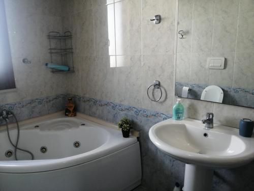 uma casa de banho com uma banheira e um lavatório em A casa di Rita em Surbo