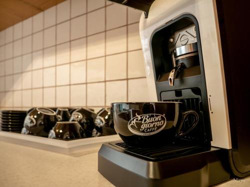 a coffee cup is sitting on a coffee maker at Moonshine Villa in Nadur