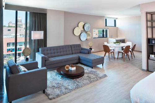 a living room with a blue couch and a table at AC Hotel by Marriott Des Moines East Village in Des Moines