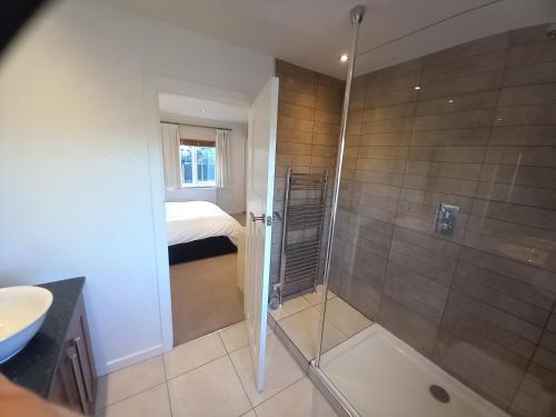 a bathroom with a shower and a bed in a room at Grange Croft in Ben Rhydding