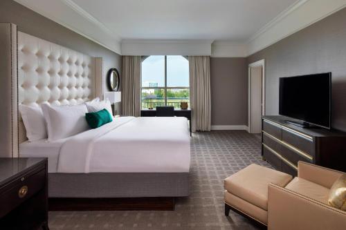 The Ballantyne, a Luxury Collection Hotel, Charlotte في تشارلوت: غرفة فندقية بسرير كبير وتلفزيون بشاشة مسطحة