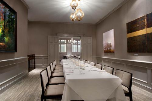 a long dining room with a white table and chairs at The Ballantyne, a Luxury Collection Hotel, Charlotte in Charlotte