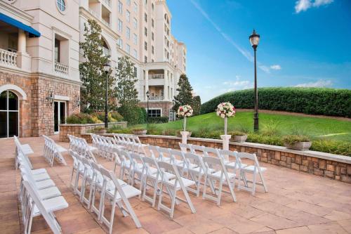 a row of white chairs in front of a building at The Ballantyne, a Luxury Collection Hotel, Charlotte in Charlotte