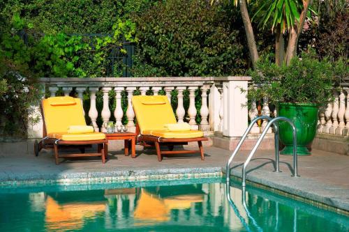 two chairs and a table next to a swimming pool at Sheraton Addis, a Luxury Collection Hotel, Addis Ababa in Addis Ababa
