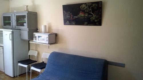 une cuisine avec une chaise bleue et un four micro-ondes dans l'établissement Gite au milieu des vignes g43, à Vidauban