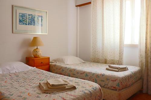 Dos camas en un dormitorio con toallas. en Ericeira - S.ta Marta en Ericeira