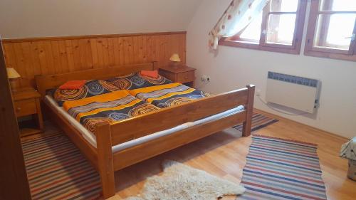 Schlafzimmer mit einem Bett mit einem Kopfteil aus Holz in der Unterkunft Chalupa pod Skleným Vŕškom in Huty
