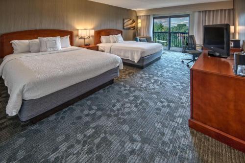 a hotel room with two beds and a television at Courtyard by Marriott Springfield in Springfield