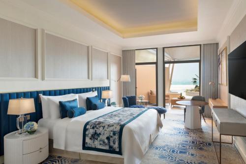 a hotel room with a bed and a view of the ocean at The St. Regis Doha in Doha