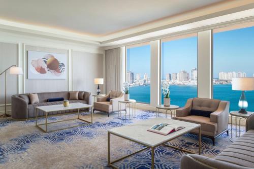 a living room with couches and a large window at The St. Regis Doha in Doha