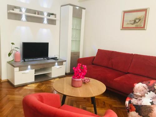 sala de estar con sofá rojo y mesa en Apartments Ana Hvar, en Hvar