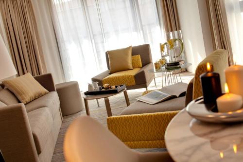 a living room with a couch and chairs and a table at Renaissance Aix-en-Provence Hotel in Aix-en-Provence